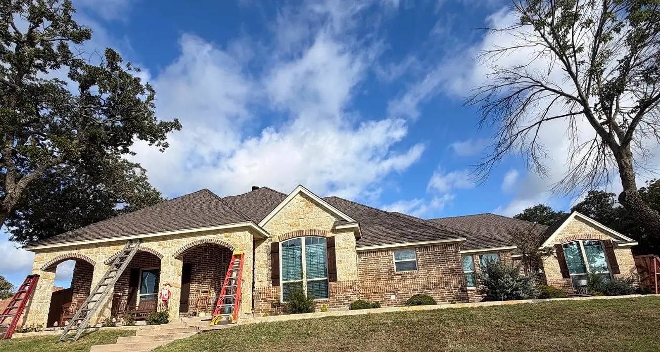 Stone home during installation, ladders at the porch